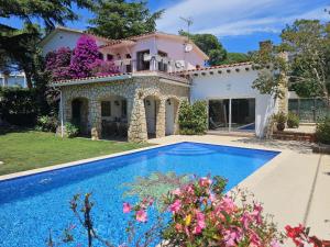 a villa with a swimming pool in front of a house at Villa Del Sol in S'Agaro