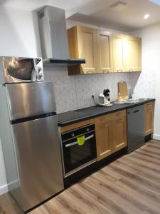 a kitchen with stainless steel appliances and wooden cabinets at Orvilliers in Moulins +12 photos