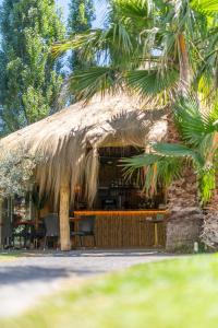 a hut with a thatched roof with tables and chairs at Hotel Isola Sacra Rome Airport in Fiumicino