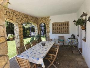 a dining room with a table and chairs and a stone wall at Villa Del Sol in S'Agaro