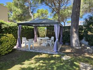 a gazebo with a table and chairs in a yard at Villa Del Sol in S'Agaro