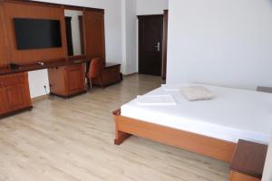 a bedroom with a bed and a flat screen tv at Hotel Restaurant Elite in Drobeta-Turnu Severin