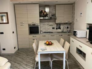 Una cocina con una mesa con un bol de fruta encima. en Casa Argegno, en Argegno