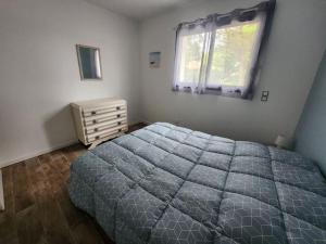 a bedroom with a large bed and a window at Maison plein centre - Piscine in Mimizan +4 photos
