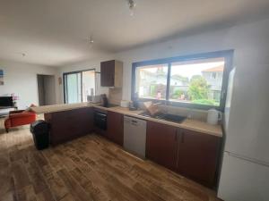 a kitchen with a large window and a counter top at Maison plein centre - Piscine in Mimizan