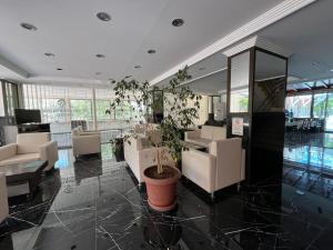 a lobby with a potted plant in the middle at Bayındır Palme Hotel in Antalya