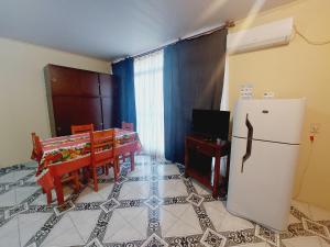 een keuken met een koelkast en een tafel met een televisie bij Apart Morel in Puerto Iguazú
