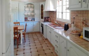 a kitchen with white cabinets and a tiled floor at Lovely Home In Villamblard With Wifi in Villamblard