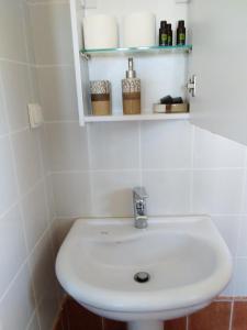 a white sink in a white tiled bathroom at Emmanouil in Kythira