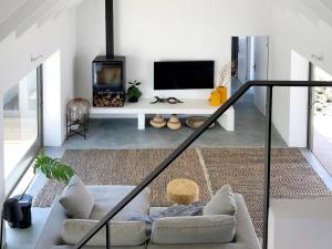 a living room with a couch and a tv at The Cottage Collection Paternoster in Paternoster