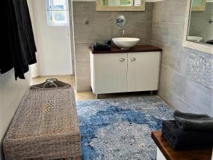 a bathroom with a sink and a counter with a mirror at The Cottage Collection Paternoster in Paternoster