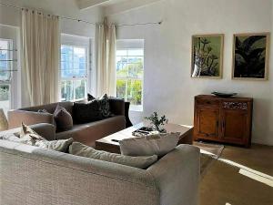 a living room with two couches and a table at The Cottage Collection Paternoster in Paternoster