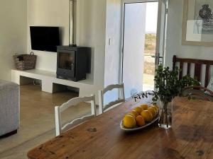 a dining room table with a plate of fruit on it at The Cottage Collection Paternoster in Paternoster