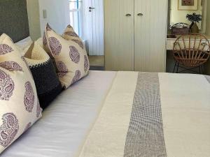 a bed with pillows on it in a room at The Cottage Collection Paternoster in Paternoster