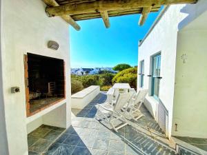 a patio with white chairs and a fireplace at The Cottage Collection Paternoster in Paternoster