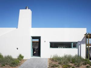 a white house with a black door and a pathway at The Cottage Collection Paternoster in Paternoster