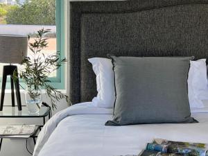 a bed with a gray pillow and a side table at The Cottage Collection Paternoster in Paternoster