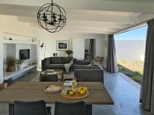 a living room with a table and a couch at The Cottage Collection Paternoster in Paternoster