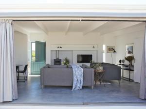 a living room with two couches and a tv at The Cottage Collection Paternoster in Paternoster