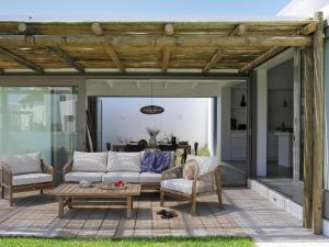 a patio with a couch and a table at The Cottage Collection Paternoster in Paternoster