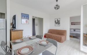 ein Wohnzimmer mit Tisch und Stühlen und einer Couch in der Unterkunft 1 Bedroom Awesome Apartment In Royan in Royan