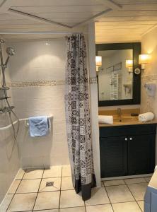 a bathroom with a shower curtain and a sink at Appartement Le Beach du Lac d'Annecy avec les pieds dans l eau, plage et ponton privé in Duingt
