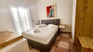 a bedroom with a bed in a room with a window at Vila Era Ksamil in Ksamil