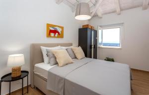 a bedroom with a large white bed with a window at Beautiful Home In Jadranovo in Jadranovo