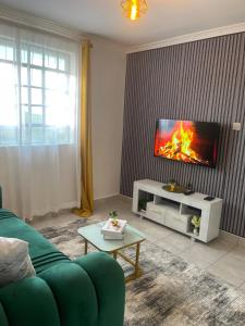 a living room with a couch and a flat screen tv at Bella Homes Thika Town in Thika