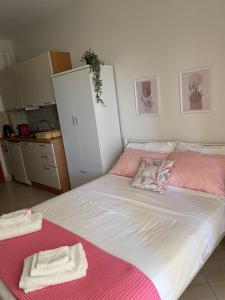 a bedroom with a bed with pink and white sheets at Chili Seaside 2 in Nea Chili