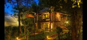 a house in the middle of a forest at night at Wayanad Kuruva Isles Jungle Resort in Chekadi
