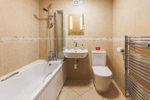 Un baño con inodoro, lavabo y bañera. en Wheel House @ Goonwinnow Farm, en Newquay 14 fotos más
