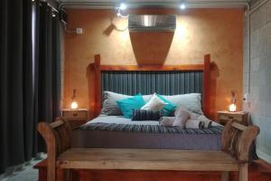 a bedroom with a bed with a wooden head board at Nelumbo Petit Chalet in San Rafael