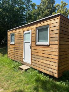 a wooden shed with a door and a window at Tetris domky v Beachklubu Ládví in Prague