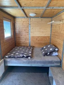 a bed in the inside of a wooden cabin at Tetris domky v Beachklubu Ládví in Prague