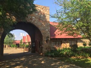 an entrance to a stone building with a red roof at Delagoa Cottage Dullstroom in Dullstroom