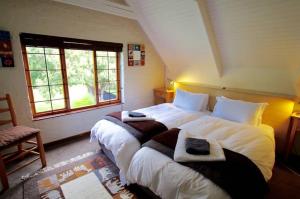a bedroom with two large beds with towels on them at Delagoa Cottage Dullstroom in Dullstroom
