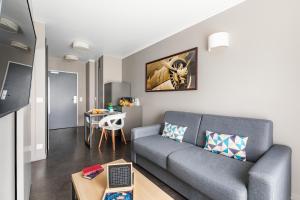a living room with a couch and a table at Appart’City Confort Le Bourget - Aéroport in Le Bourget
