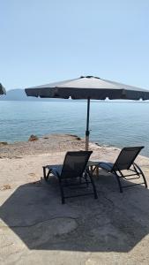 two chairs and an umbrella on a beach at Christinas 3 in Nerántza +18 photos