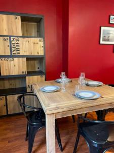 a wooden table with plates and wine glasses on it at Auron - 4 personnes - Hypercentre in Bourges