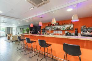 a bar in a restaurant with black stools at Appart’City Confort Le Bourget - Aéroport in Le Bourget