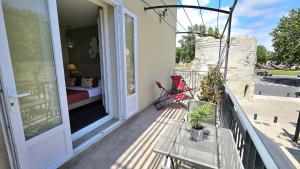 a balcony with a table and chairs on a porch at Brit Hotel Acacias in Arles