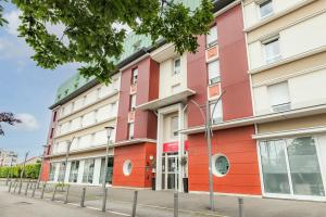 a red and white building on a street at Appart’City Confort Le Bourget - Aéroport in Le Bourget