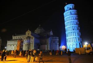 um grupo de pessoas em pé em frente a uma grande torre em Alla Torre Con Vista em Pisa