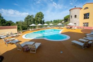 a large swimming pool with chairs and a building at S'ena Hotel in Arbus