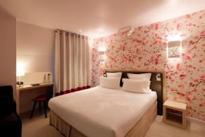 a bedroom with a bed with a flowery wall at Hotel Eden in Paris