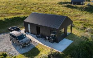 una vista dall'alto di un'auto parcheggiata davanti a una piccola casa di Svartaborg a Húsavík