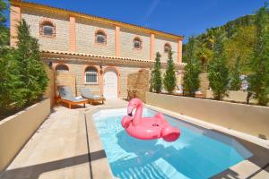 una piscina con fenicottero rosa gonfiabile di fronte a un edificio di Doliva Studio Chris private pool ad Agios Gordios
