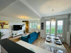 a living room with a blue couch and a tv at Yucca, Appartement avec garage privé et balcon in Caen