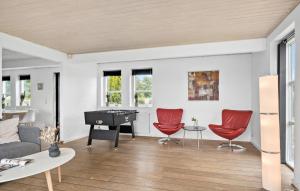 a living room with a piano and red chairs at Cozy Home In Haderslev With Wifi in Haderslev